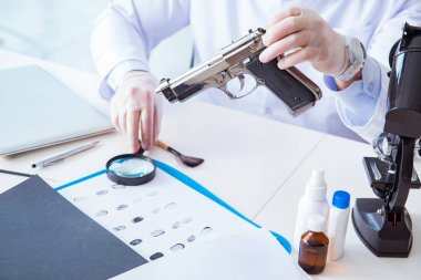 Kriminolog polis kimyageri suç delillerine bakıyor.