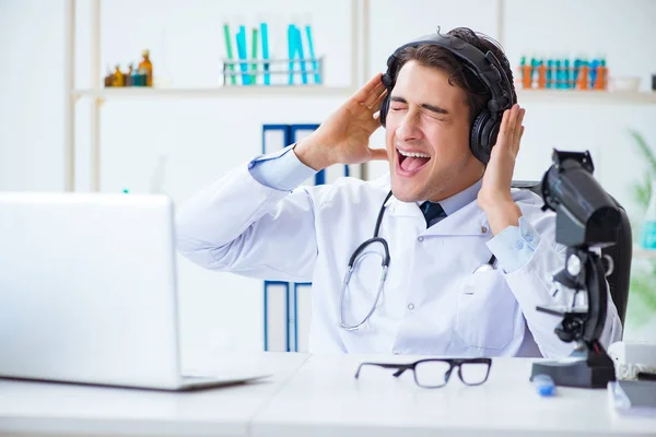 Feliz médico emocionado escuchando música durante la pausa del almuerzo en el hospital — Foto de Stock