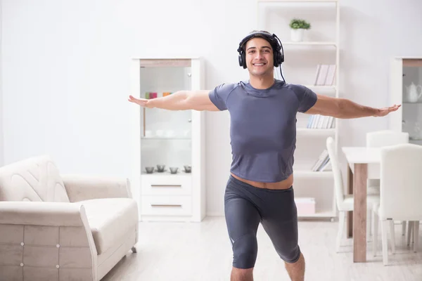 Hombre haciendo deportes en casa y escuchando música —  Fotos de Stock