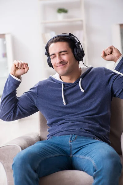Jongeman die thuis naar muziek luistert — Stockfoto