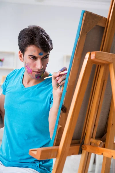 Młody zabawny artysta pracujący nad nowym malarstwem w swoim studio — Zdjęcie stockowe