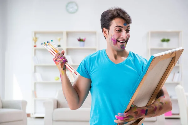 Young funny artist working on new painting in his studio — Stock Photo, Image