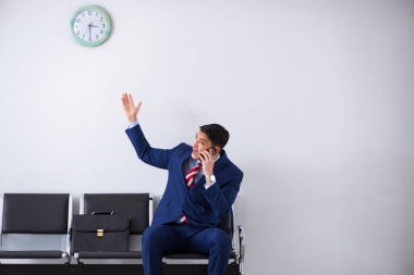 Havaalanı dinlenme odasında yolcu bekleyen adam.