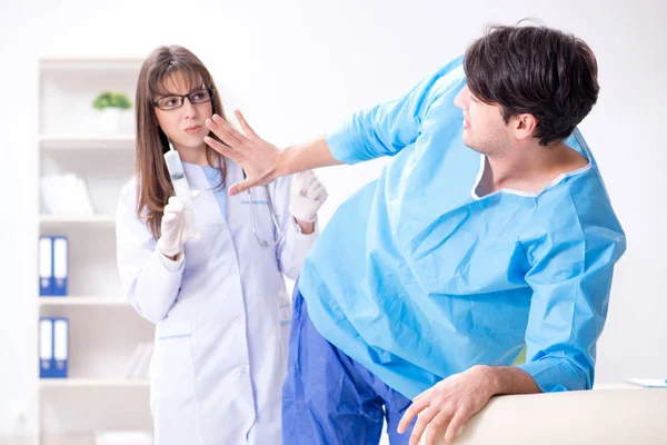 Komik adam şırınga iğnesine hazırlanıyor.