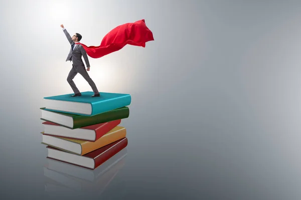 Homem de negócios super-herói no conceito de educação com livros — Fotografia de Stock