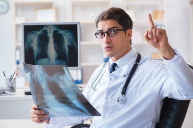 Doktor radyoloji uzmanı röntgen görüntülerine bakıyor.