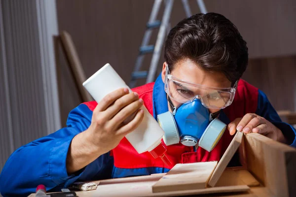 Jeune homme collant des pièces de bois ensemble dans le concept de bricolage — Photo