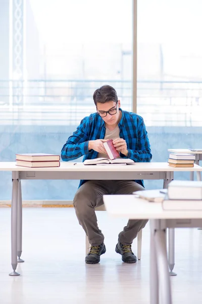 Studerande studerar i det tomma biblioteket med bok förbereder sig för ex — Stockfoto