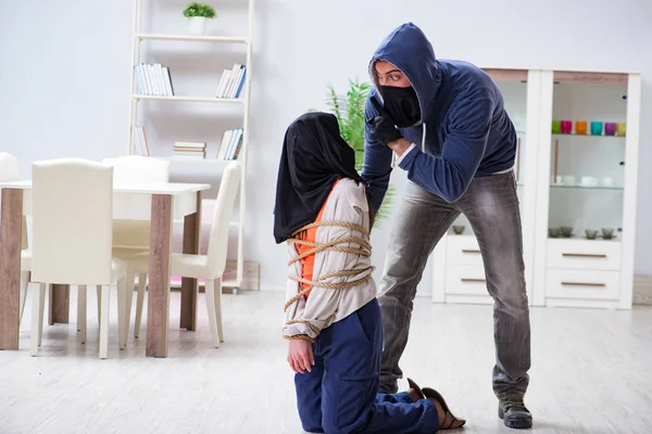 Armado homem assaltando jovem mulher em casa — Fotografia de Stock