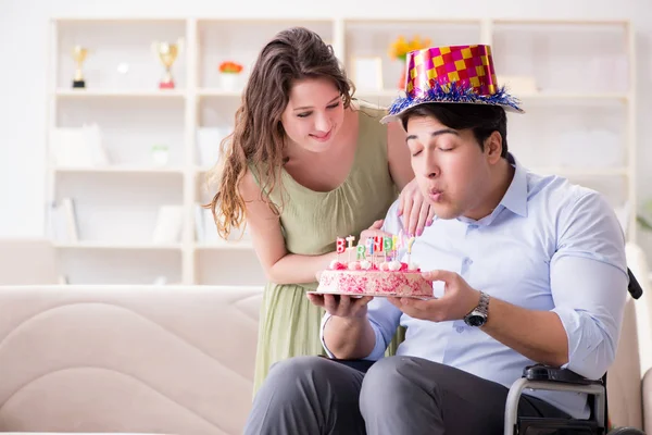 Young family celebrating birthday with disabled person