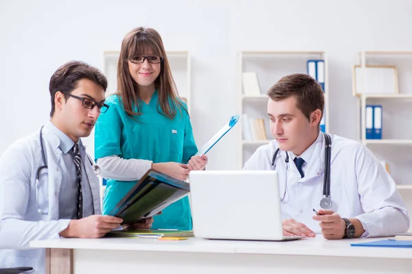 Tres médicos discutiendo los resultados de la exploración de la imagen de rayos X — Foto de Stock