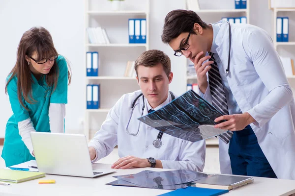 Tres médicos discutiendo los resultados de la exploración de la imagen de rayos X — Foto de Stock