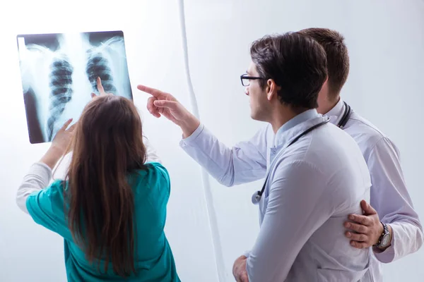 Три врача обсуждают результаты сканирования рентгеновского изображения — стоковое фото