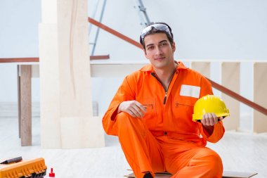 Müteahhit atölyesinde sarı şapka takan marangoz.
