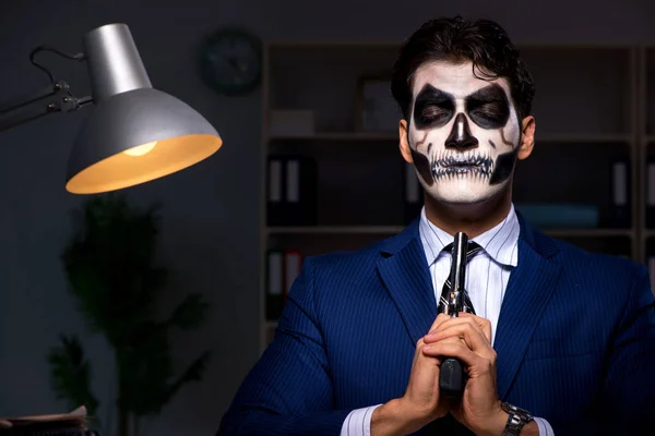 Uomo d'affari con maschera spaventosa che lavora fino a tardi in ufficio — Foto Stock