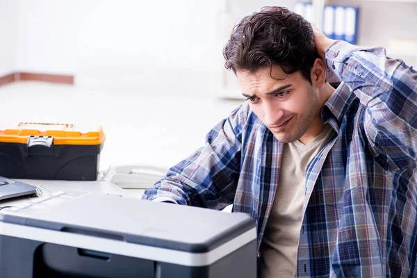 Ремонтник оборудования ремонтирует сломанный факс принтера — стоковое фото