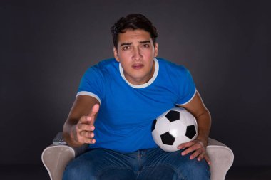 Gri arka planda spor izleyen adam