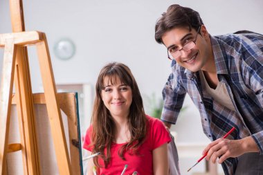 Stüdyoda resim sınıfında sanatçı koçluğu yapan bir öğrenci.