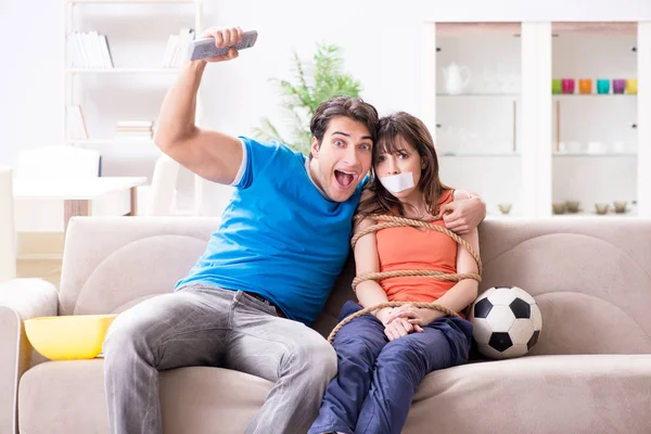 Man bindt zijn vrouw vast om sportvoetbal te kijken — Stockfoto