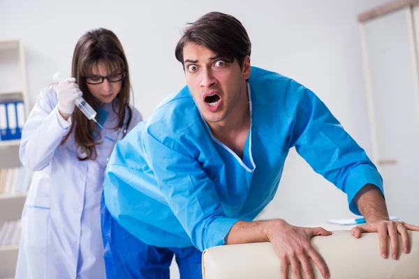 Funny man getting ready for buttocks syringe shot — Stock Photo, Image