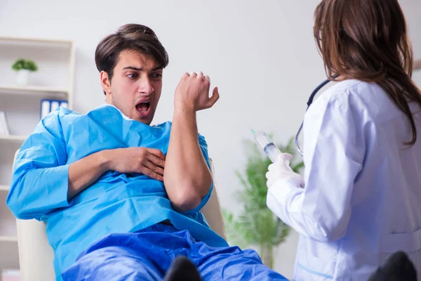 Испуганный терпеливый человек готовится к прививке от гриппа — стоковое фото