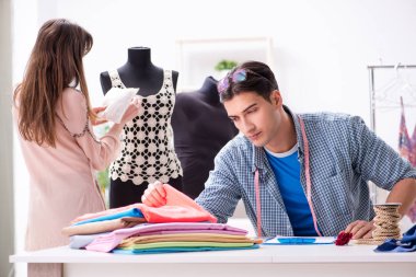 Atölyede erkek terzi ve bayan öğrenci.