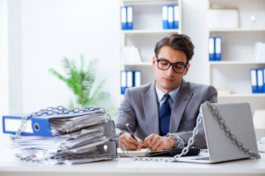 Ofis masasına zincirlenmiş meşgul bir çalışan.