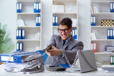 Ofis masasına zincirlenmiş meşgul bir çalışan.