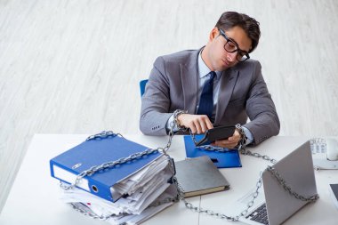 Ofis masasına zincirlenmiş meşgul bir çalışan.