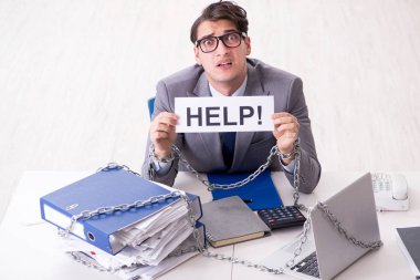 Ofis masasına zincirlenmiş meşgul bir çalışan.