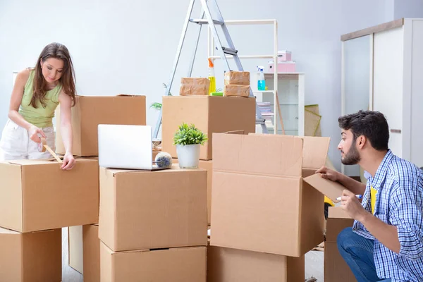 Jovem família desembalagem em nova casa com caixas — Fotografia de Stock