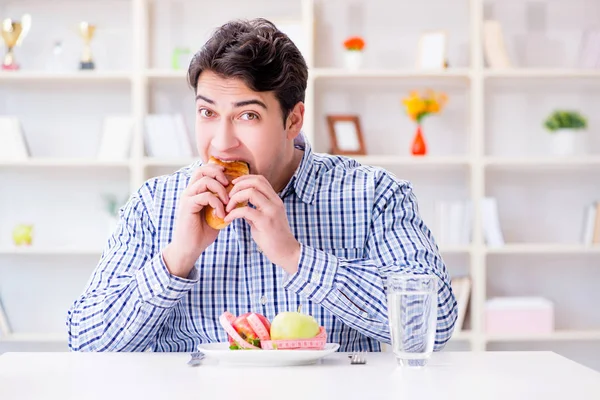 Человек, имеющий дилемму между здоровой пищей и хлебом в мошенничестве — стоковое фото