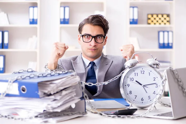 Busy employee chained to his office desk — Stock Photo, Image