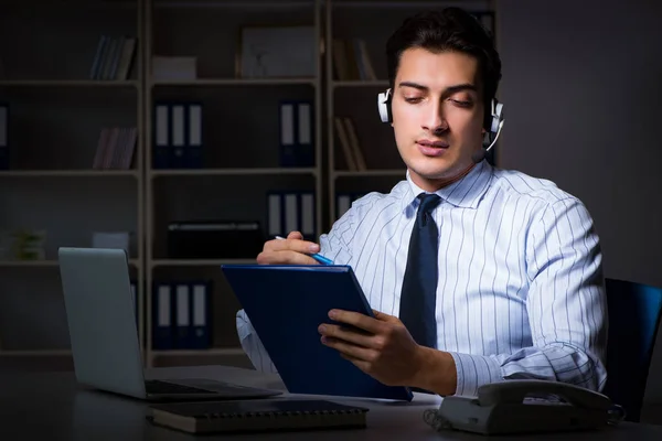 Operador de call center conversando com o cliente durante o turno da noite — Fotografia de Stock