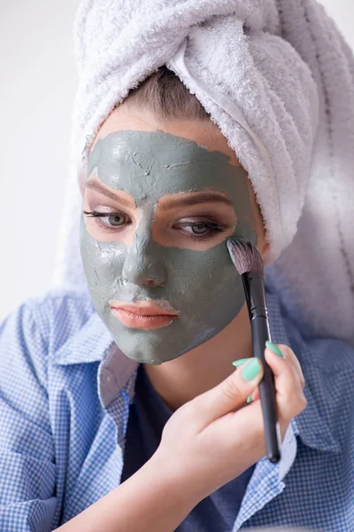 Mujer aplicando mascarilla de barro con cepillo en casa — Foto de Stock