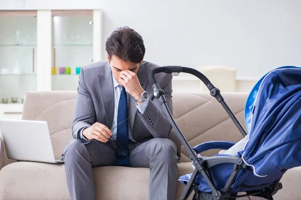 Affärsman som tar hand om det nyfödda barnet hemma och distansarbetar — Stockfoto