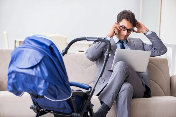 Businessman looking after newborn baby at home and teleworking — Stock Photo, Image