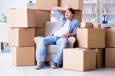 Genç adam kutularla yeni eve taşınıyor.