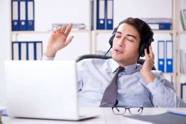 Satış asistanı öğle arasında müzik dinliyor.