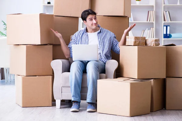 Young man moving in to new house with boxes — Stock Photo, Image