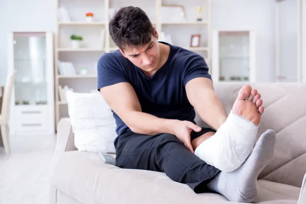 Hombre con la pierna rota recuperándose en casa —  Fotos de Stock