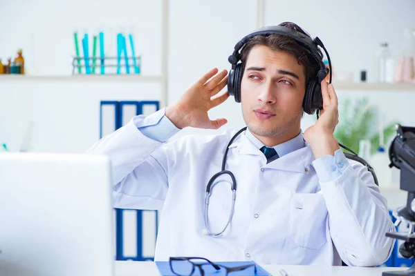 Feliz médico emocionado escuchando música durante la pausa del almuerzo en el hospital — Foto de Stock