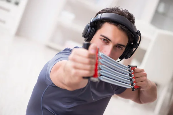 Человек занимается спортом с группой сопротивления и слушает музыку — стоковое фото