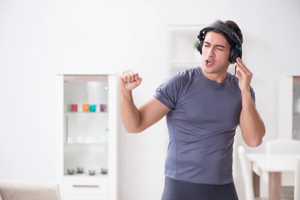 Man idrottar hemma och lyssnar på musik — Stockfoto