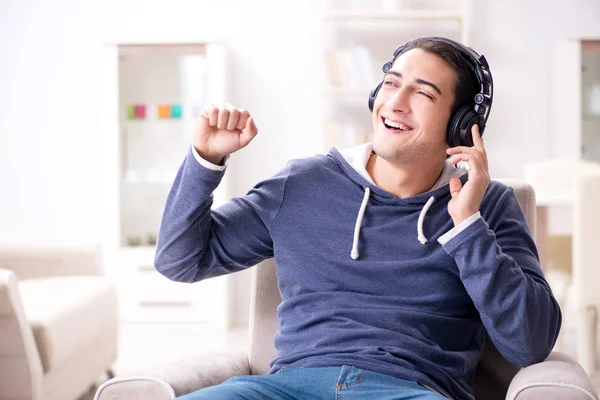 Genç adam evde müzik dinliyor. — Stok fotoğraf