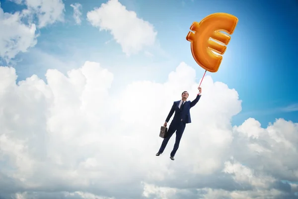 Businessman flying on euro sign inflatable balloon