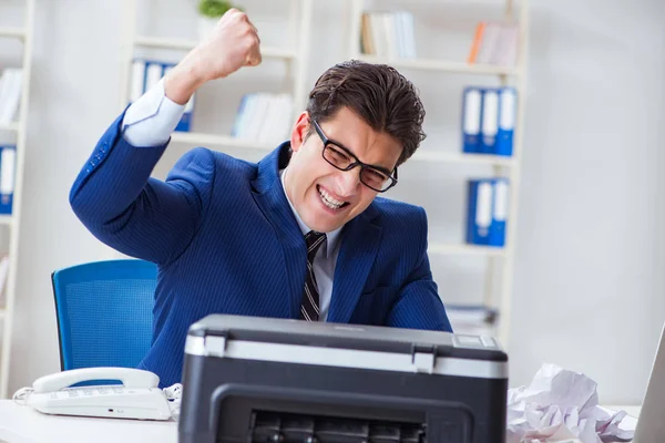 Businessman angry at copying machine jamming papers — Stock Photo, Image