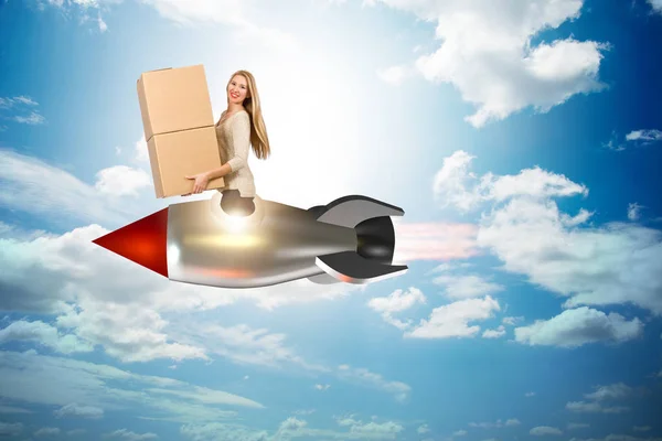 Woman in fast box delivery service on rocket — Stock Photo, Image