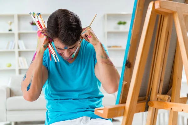 Młody zabawny artysta pracujący nad nowym malarstwem w swoim studio — Zdjęcie stockowe