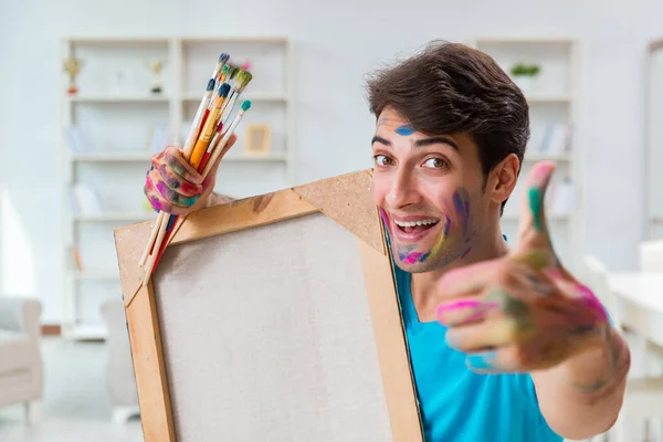 Young funny artist working on new painting in his studio — Stock Photo, Image